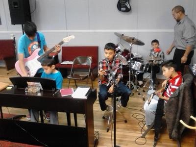 Kids practicing in church Josh is the one standing with the guitar, by the piano.